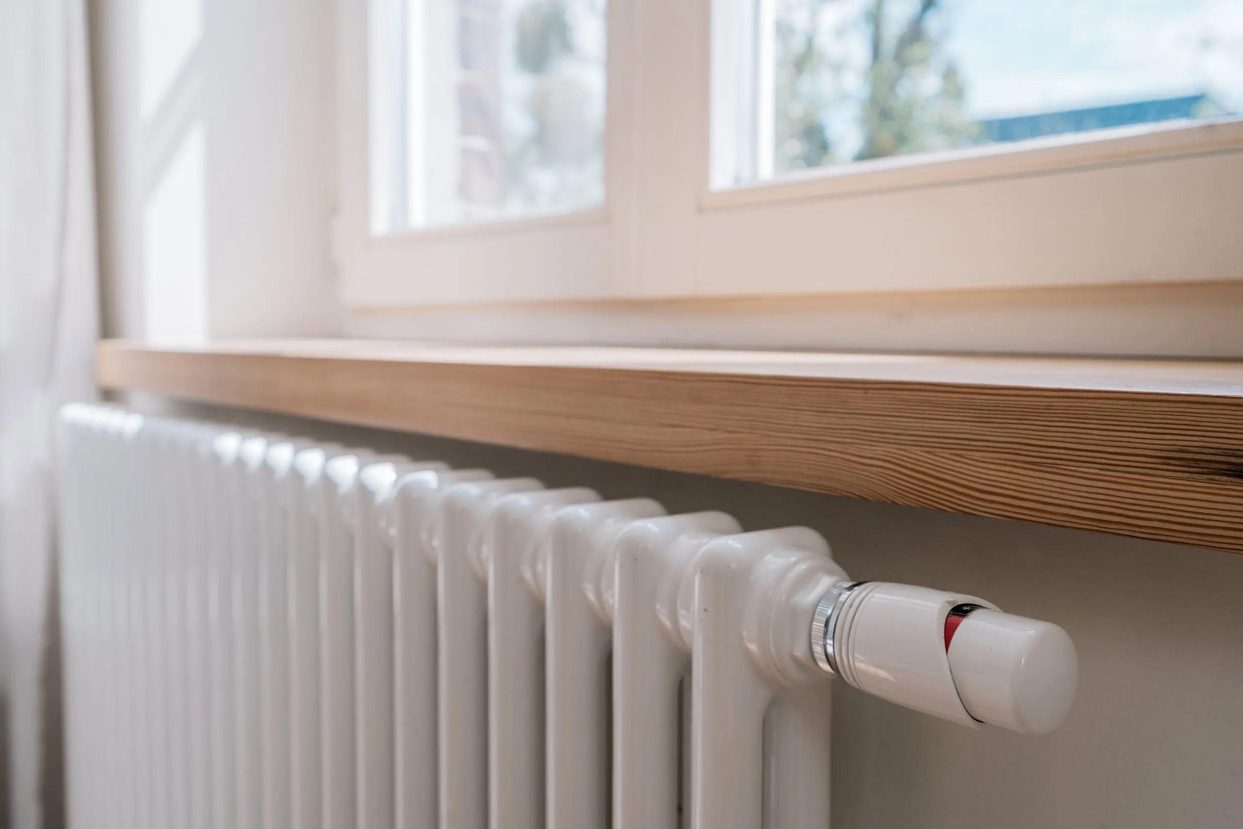 Heizkörper mit Thermostat unter einer Fensterbank