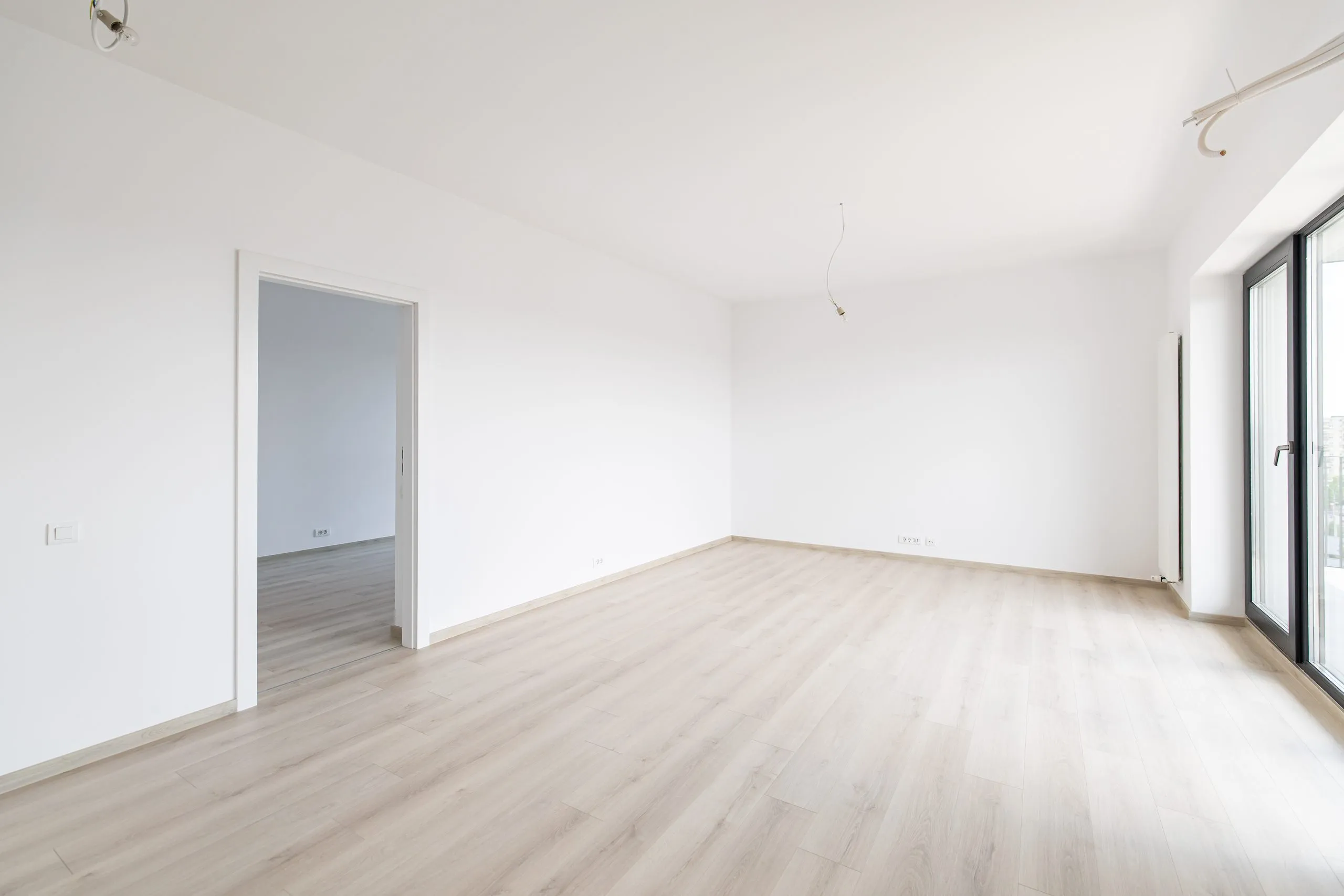 Leere helle Wohnung mit Fenster und offener Zimmertür